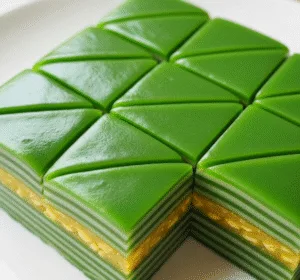 Đĩa bánh cắt lát đẹp mắt làm từ công thức bánh da lợn lá dứa đậu xanh, thể hiện rõ các lớp bánh đều và mịn